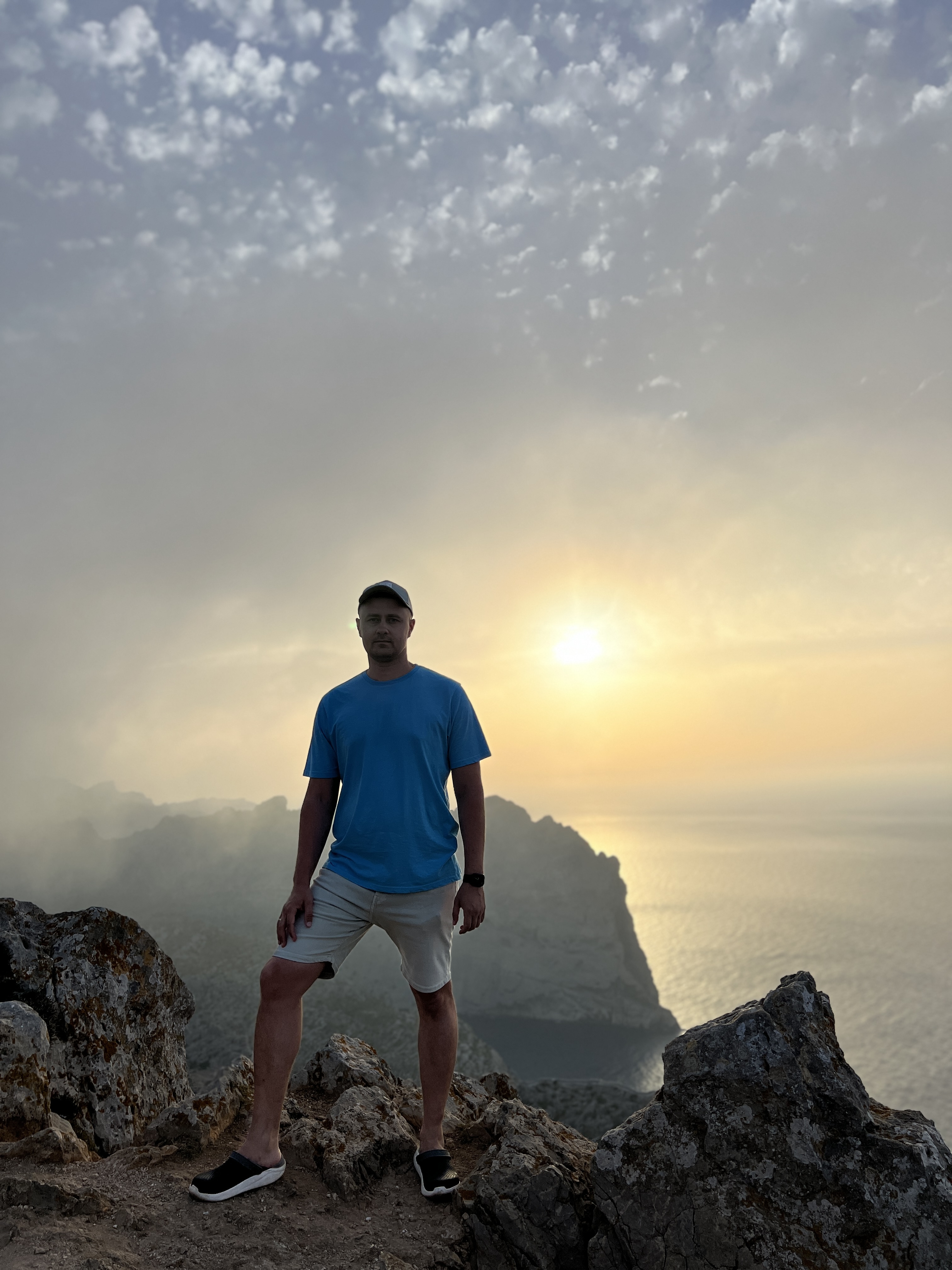 Dzmitry Astraukh standing on a mountain peak at sunset